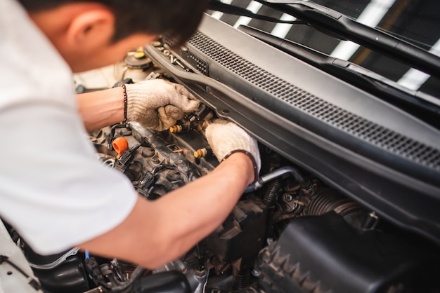 Foto los técnicos automotrices están revisando los sistemas de inyección de automóviles utilizando herramientas de diagnóstico y reparación en la sala de máquinas para vehículos automotores.