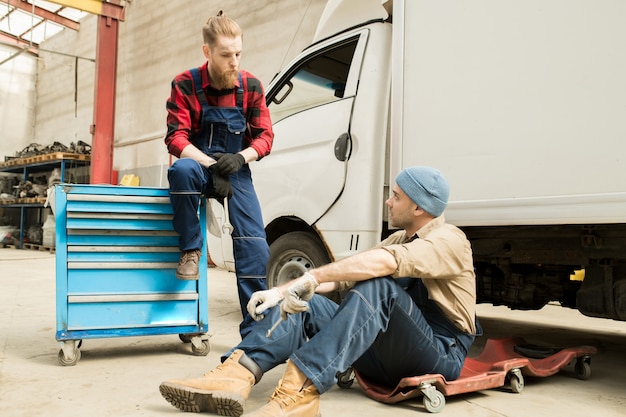 Técnicos de automóveis discutindo reparação