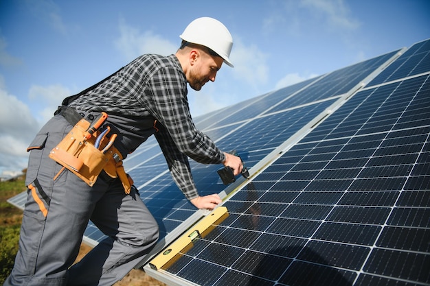 Técnicos de homens instalando módulos solares fotovoltaicos Conceito de energia alternativa e renovável