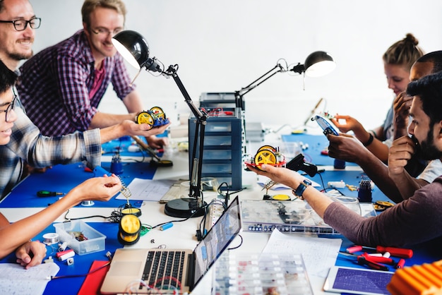 Foto técnicos eléctricos trabajando en piezas de robot.