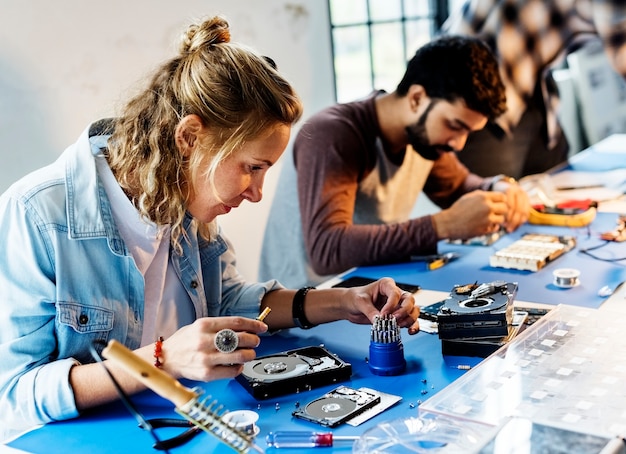 Técnicos elétricos trabalhando em peças de computador