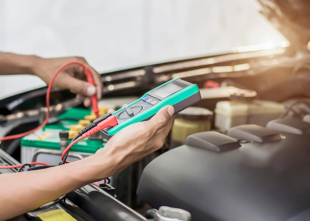 Foto los técnicos inspeccionan el sistema eléctrico de los coches.