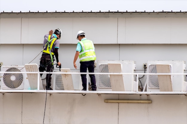 Técnicos inspecionando equipamentos e limpeza de condicionadores de ar externos, manutenção e manutenção de condicionadores de ar em plantas industriais