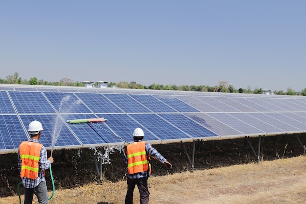 Técnicos para limpar células solares em uma planta solar