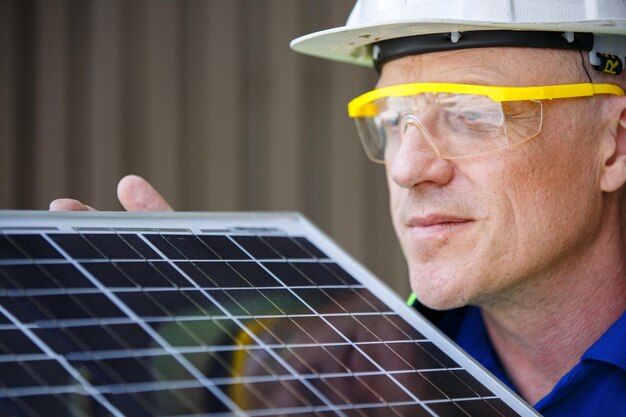 Técnicos que mantienen el panel solar y verifican la celda que trabaja con una tableta para la renovación alternativa del hogar