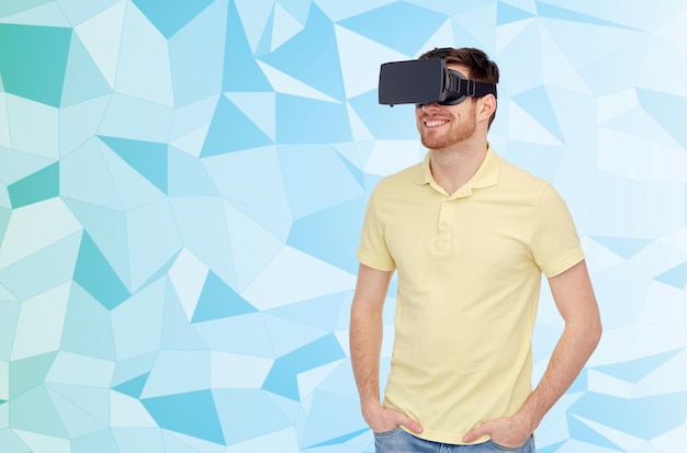 Tecnología 3d, realidad virtual, entretenimiento y concepto de personas: joven feliz con casco de realidad virtual o gafas 3d sobre fondo azul de textura polivinílica baja,