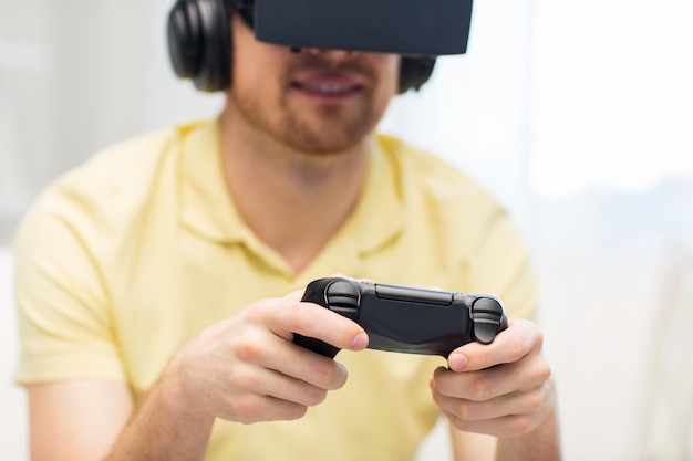 Tecnología 3d, realidad virtual, juegos, entretenimiento y concepto de personas: cierre de un hombre con auriculares de realidad virtual o gafas 3d y auriculares jugando videojuegos con un mando en casa