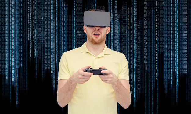 tecnologia 3d, realidade virtual, entretenimento e conceito de pessoas - jovem feliz com fone de ouvido de realidade virtual ou óculos 3d jogando com gamepad de controlador de jogo sobre fundo de código binário