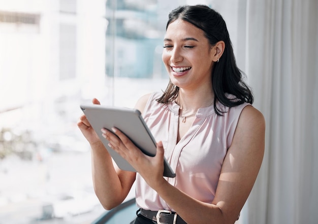 La tecnología alivia la carga de trabajo Captura de una atractiva joven empresaria sola en la oficina y usando una tableta digital