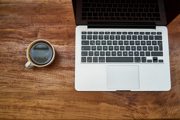 Tecnología y café en una mesa de madera