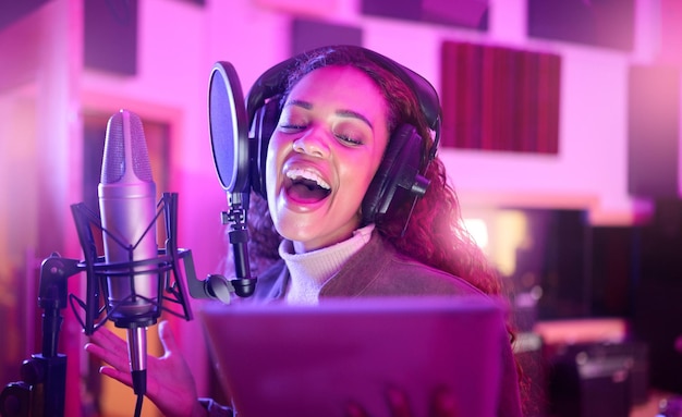 Tecnología cantando o músico en letras de estudio de música de micrófono de neón o aplicación de composición de canciones en grabación nocturna Mujer cantante o artista en tableta en medios de producción de voz o rendimiento de luz de sonido
