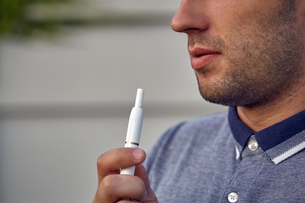 Tecnología de cigarrillos electrónicos. IQOS. primer plano, de, un, hombre, fumar, un, eléctrico, híbrido