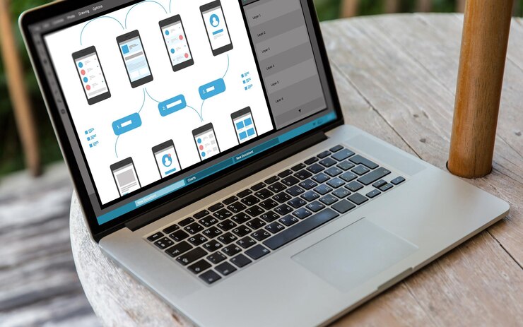 Foto tecnología y concepto de diseño web computadora portátil con interfaz de teléfono inteligente en la pantalla en la mesa en la oficina