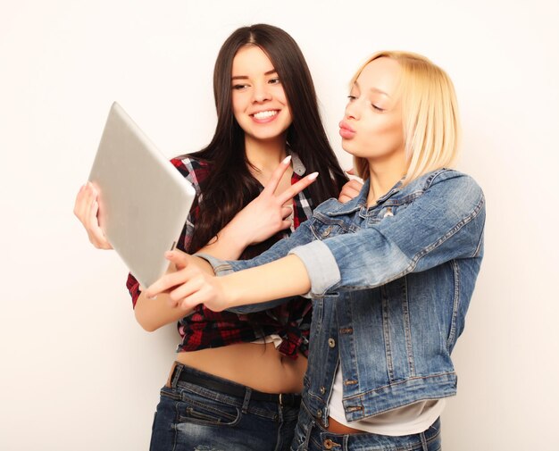 Tecnologia de estilo de vida e conceito de pessoas Meninas felizes com computador tablet sobre fundo branco Selfie feliz