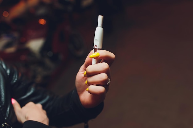 Foto tecnologia de produtos de tabaco não queimados por calor mulher segurando um e-cigarro na mão antes de fumar