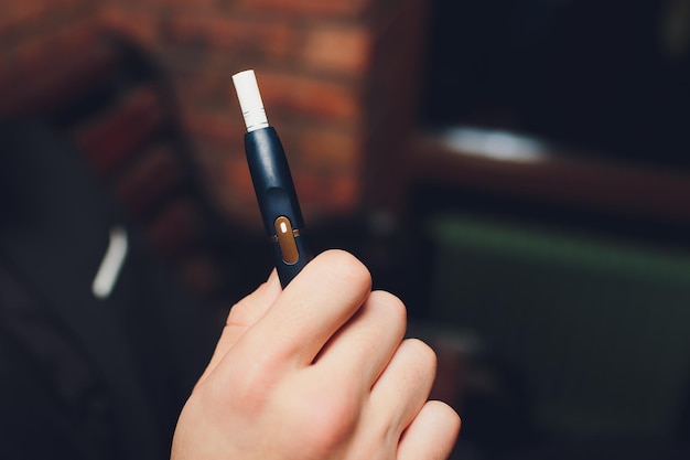 Tecnologia de produtos de tabaco não queimados por calor mulher segurando um e-cigarro na mão antes de fumar