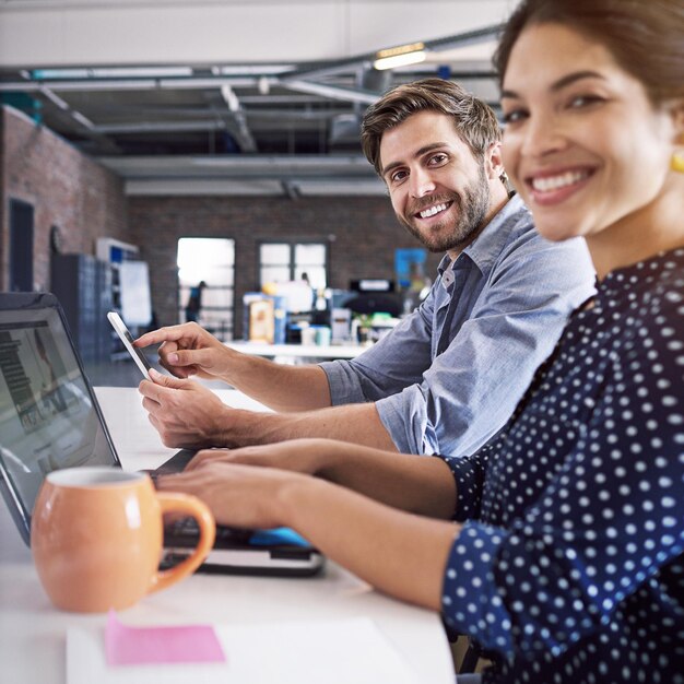 Foto tecnologia de trabalho em equipe e retrato do empresário e da mulher na mesa com o laptop na agência criativa trabalhando juntos no projeto da web colaboração feliz funcionários ou empresários na inicialização do design