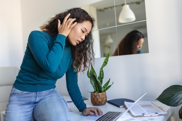 Tecnologia de trabalho remoto e conceito de pessoas feliz sorridente jovem empresária asiática com laptop e papéis trabalhando no escritório doméstico