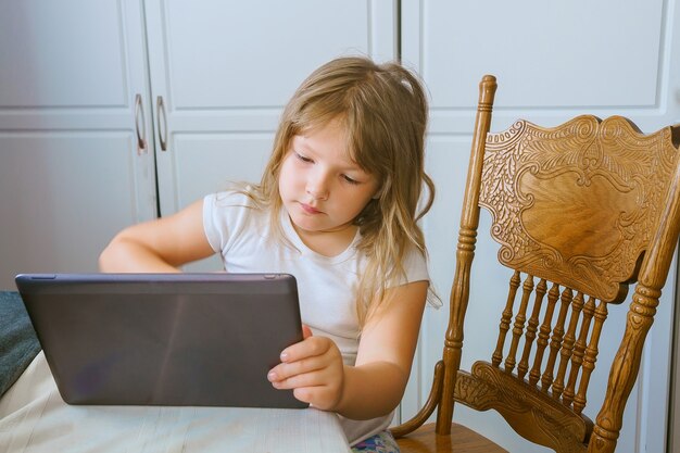 Tecnologia educacional e conceito de internet - menina estudante com tablet pc em casa