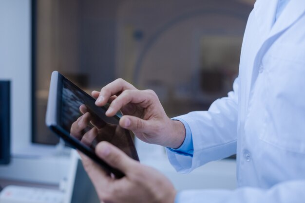 Tecnologia em uso. close-up de um tablet moderno e inovador nas mãos dos médicos enquanto é usado para o trabalho