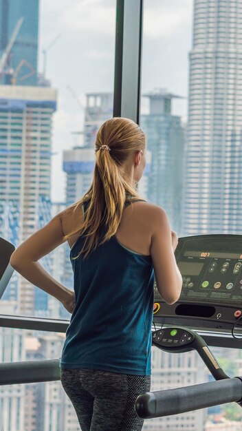 Tecnología de estilo de vida de fitness deportivo y concepto de personas mujer haciendo ejercicio en cinta de correr en el gimnasio contra