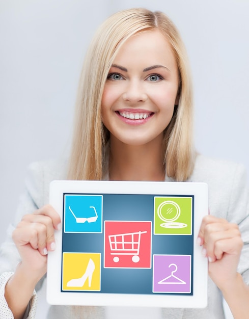 tecnología, gente y concepto de compras en línea - mujer sonriente mostrando la pantalla de la computadora de tablet pc con iconos de moda sobre fondo gris