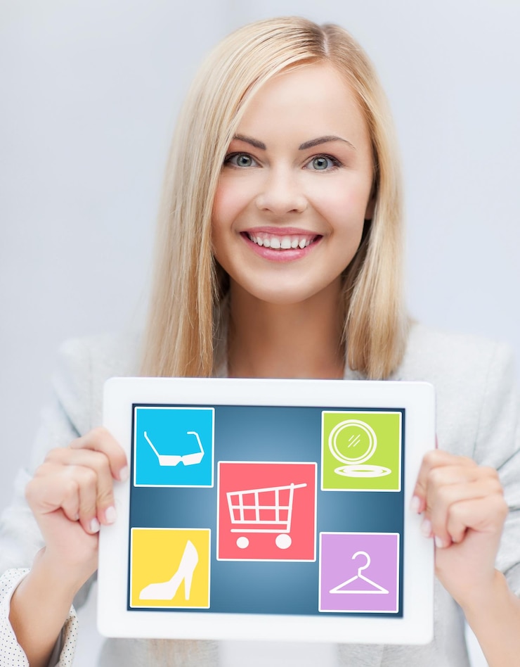 Foto tecnología, gente y concepto de compras en línea - mujer sonriente mostrando la pantalla de la computadora de tablet pc con iconos de moda sobre fondo gris