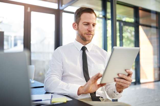 La tecnología impulsa la innovación Captura recortada de un hombre de negocios que trabaja en una tableta digital en una oficina moderna