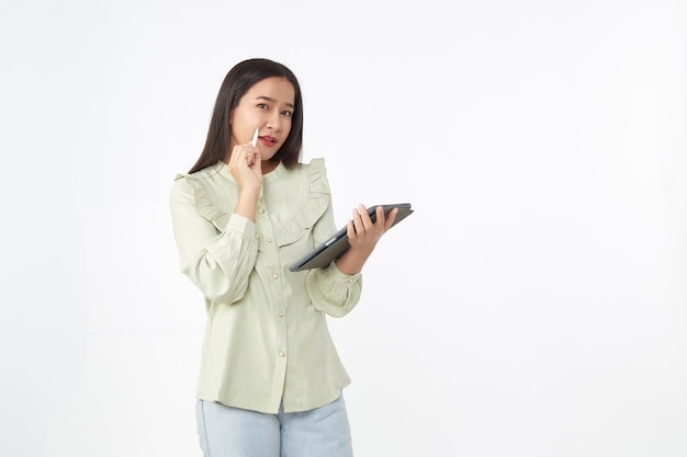 Tecnología inalámbrica. Hermosa joven asiática sosteniendo tableta digital y mirando a la cámara con una sonrisa mientras está de pie aislado sobre fondo blanco.