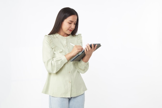 Tecnología inalámbrica. Hermosa joven asiática sosteniendo tableta digital y mirando a la cámara con una sonrisa mientras está de pie aislado sobre fondo blanco.