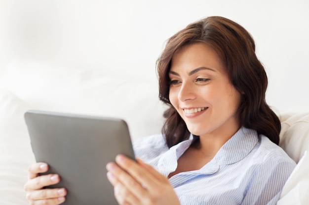 tecnologia, internet e conceito de pessoas - mulher sorridente com computador tablet pc em casa
