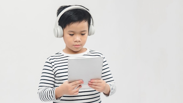 Tecnología un joven alumno encantador de pie con su tableta con auriculares