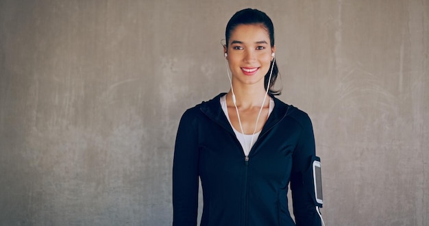 La tecnología moderna hace que hacer ejercicio sea una actividad feliz Retrato de estudio recortado de una mujer joven y atractiva que escucha música mientras hace ejercicio