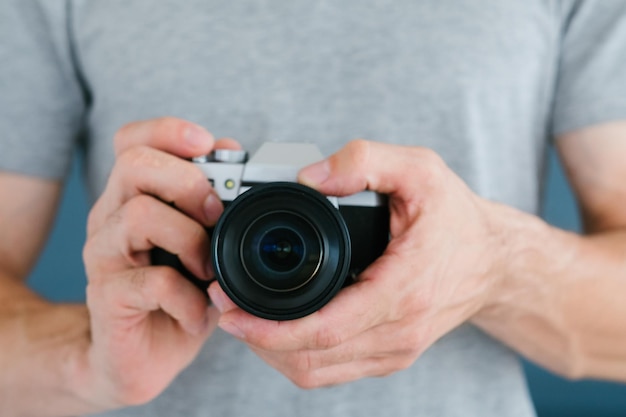 Tecnologia moderna para criação de conteúdo de foto e vídeo homem irreconhecível segurando a câmera em mãos blogando equipamentos e ferramentas conceito