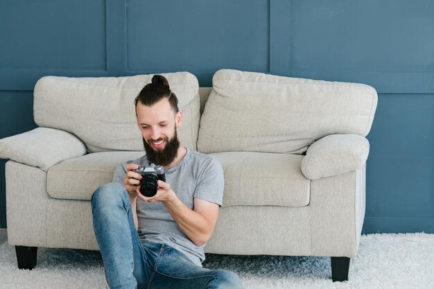 Tecnologia moderna para criação de conteúdo de foto e vídeo homem segurando a câmera nas mãos e olhando fotos ou filmagens ele fez o conceito de equipamentos e ferramentas de blogueiro