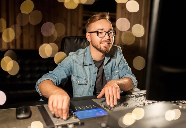 tecnología musical personas y equipos concepto hombre en la consola de mezcla en el estudio de grabación de sonido sobre las luces