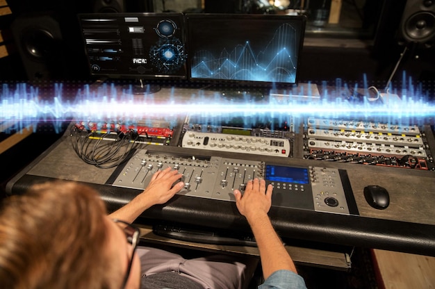 Foto tecnología musical personas y equipos concepto hombre en la consola de mezcla en el estudio de grabación de sonido