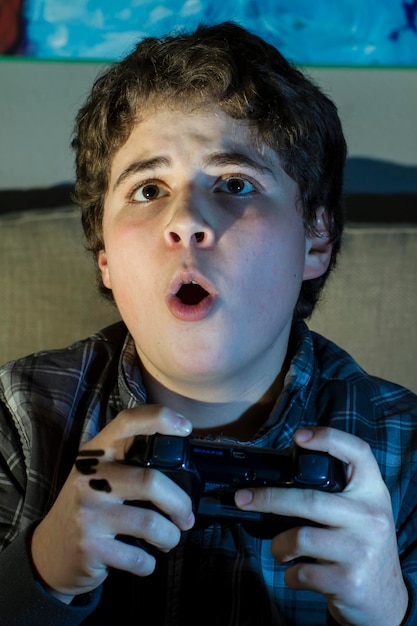 Tecnología. niño con joystick jugando juegos de computadora en casa.