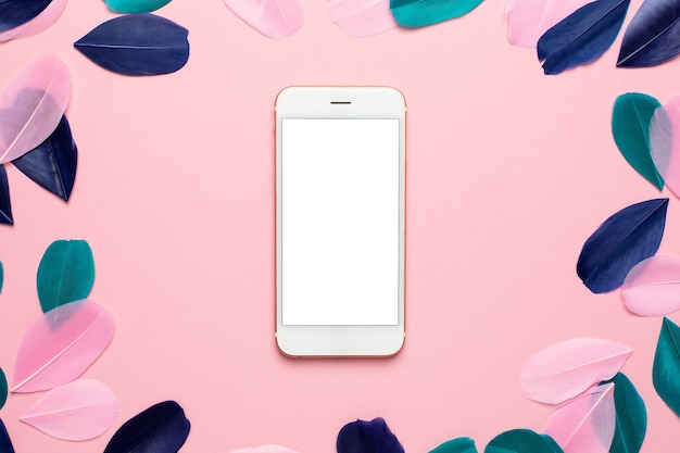 Tecnologia para maquete com belas penas verdes e azuis rosa abstratas e smartphone.