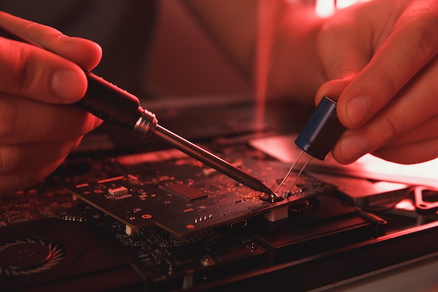 Tecnología de PC. Taller de reparación de computadoras. Ingeniero realizando mantenimiento de portátiles. Desarrollador de hardware arreglando componentes electrónicos.