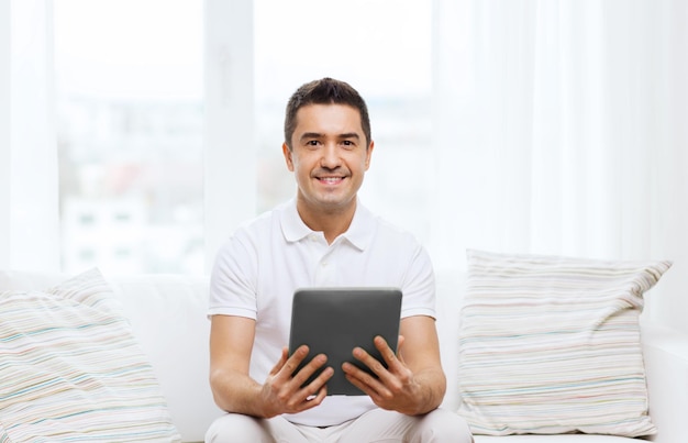 tecnología, personas y estilo de vida, concepto de aprendizaje a distancia - hombre feliz trabajando con una computadora de tablet pc en casa