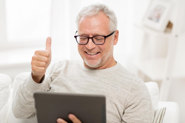 tecnologia, pessoas e estilo de vida, conceito de ensino à distância - homem sênior feliz com computador tablet pc com videochamada em casa
