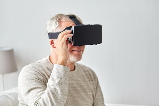 tecnología, realidad aumentada, juegos, entretenimiento y concepto de personas - hombre mayor con auriculares virtuales o gafas 3d jugando videojuegos en casa