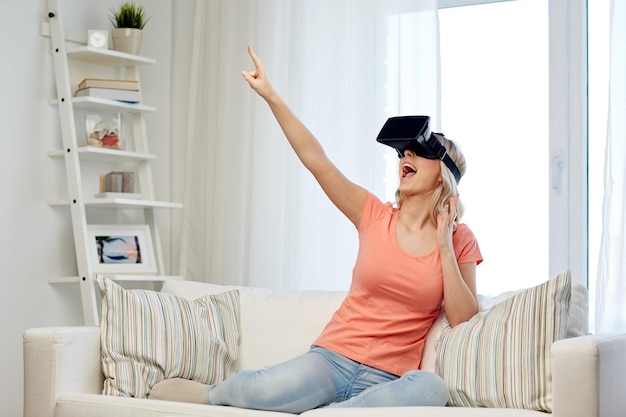 tecnologia, realidade virtual, entretenimento e conceito de pessoas - jovem feliz com fone de ouvido de realidade virtual ou óculos 3d jogando em casa e tocando em algo invisível