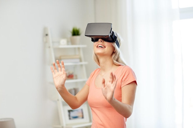 tecnologia, realidade virtual, entretenimento e conceito de pessoas - jovem feliz com fone de ouvido de realidade virtual ou óculos 3d jogando em casa e tocando em algo invisível