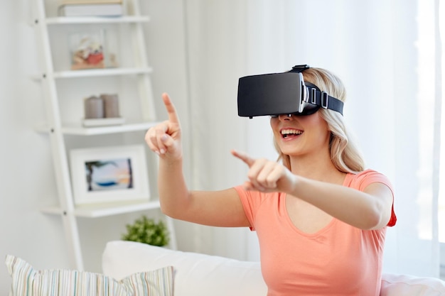 tecnologia, realidade virtual, entretenimento e conceito de pessoas - jovem feliz com fone de ouvido de realidade virtual ou óculos 3d jogando em casa e tocando em algo invisível
