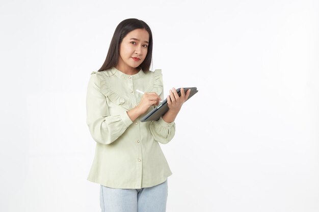 Tecnologia sem fio. Mulher jovem e bonita asiática segurando o tablet digital e olhando para a câmera com um sorriso em pé, isolado no fundo branco.