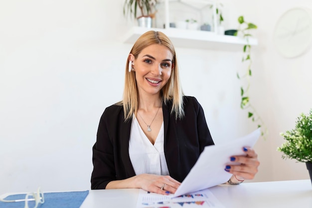 Tecnología de trabajo remoto y concepto de personas mujer de negocios joven feliz y sonriente con computadora portátil y papeles trabajando en la oficina de casa durante la crisis de salud de Covid-19