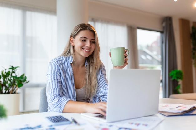 Tecnología de trabajo remoto y concepto de personas mujer de negocios joven sonriente feliz con computadora portátil y papeles que trabajan en la oficina en casa