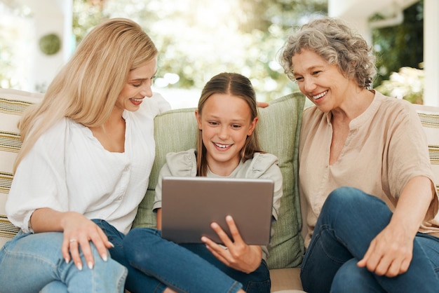 La tecnología une a la familia. Fotografía de una abuela pasando tiempo con su hija y su nieta mientras usa una tableta digital.